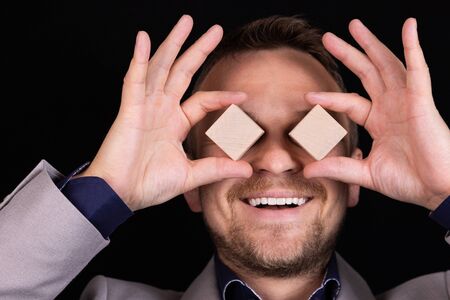 Businessman expresses emotion with his hands and face with wooden blocks. Business concept for...