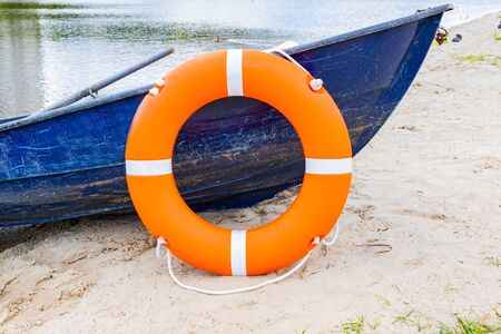 Life buoy hanging on board the boat. The boat stands on the banks of the river. Water safety...