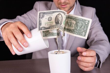 Concept of profit growth on deposit. A businessman is watering a money tree.の写真素材