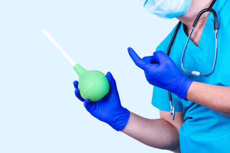 Enema in the doctor hand. Colon lavage medical concept, prevention.の写真素材