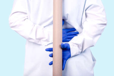 Physiotherapist shows the problem areas on the model of the spine to patient and explains the cause of her pain.の写真素材