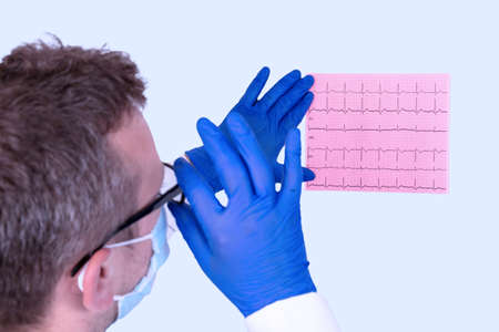 Doctor looks at the cardiogram of the heart to establish a diagnosis. Medical concept.