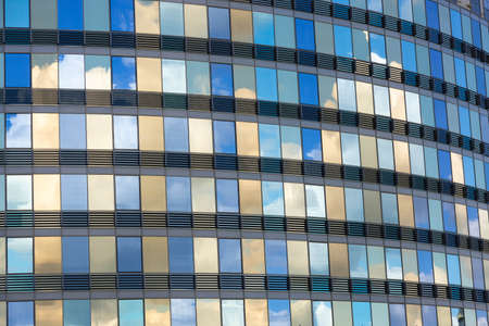 Clouds reflected in windows of modern office building