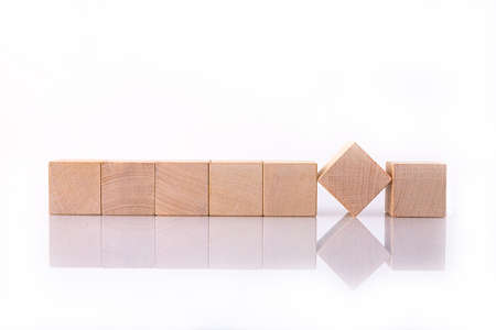 Seven wooden cubes with blank copy space for words, messages, lie on a white reflective background. Business idea.の写真素材