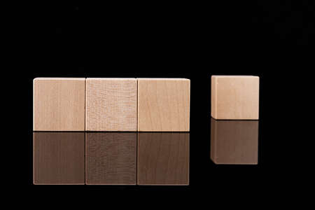 Four wooden cubes, blocks with empty space for copying words, messages, lie on a black reflective background. Business idea.の写真素材