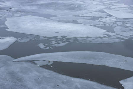 Spring thin ice on the surface of the river. Ice drift.
