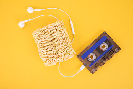 White headphones and noodles, pasta, spaghetti, instant food. The concept of using wireless...