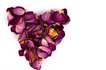 Heart shaped pressed dried rose petals, light background, vintage tone. Copy space.の写真素材
