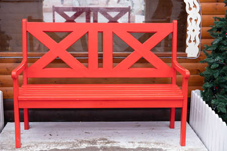 Red, empty wooden bench outside in winter.の写真素材