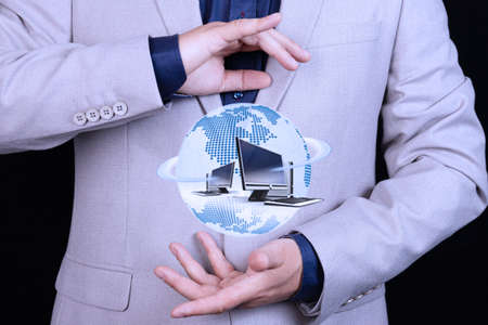 Businessman holds in hand Globe icon with computers, world wide web, web, internet technologies....
