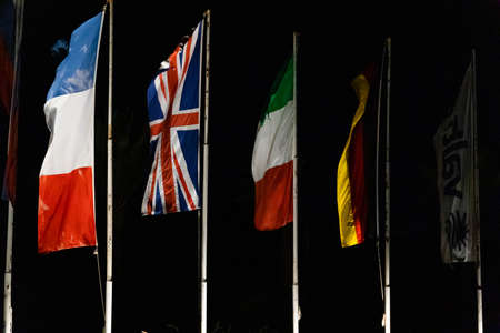 Waving flag of Germany, England, France, Italy in the night sky. State symbol on wavy cotton fabric.