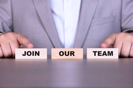 Join our team, business concept, technology. The text is written on wooden blocks on the background of a businessman.の写真素材
