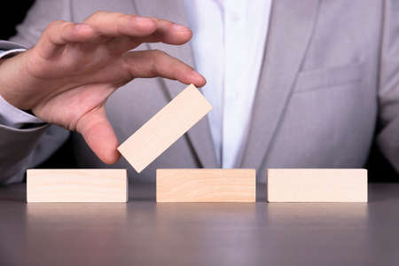 Purpose, plan, strategy, action. Wooden blocks on the background of a businessman sitting at the...