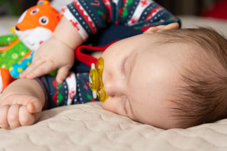Sleeping cute baby, three months old, with toys. Selective focus.の写真素材