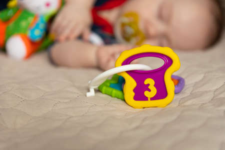 Sleeping cute baby, three months old, with toys. Selective focus.の写真素材