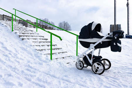 The child sleeps in a stroller in the winter. The concept of winter walks with children in the fresh...