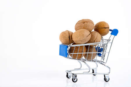Organic fresh harvested walnuts in shells in trolley from supermarket on white background. Copy spaceの写真素材