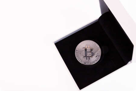 Platinum bitcoin in a white gift box with black velvet on a white background. Copy space.の写真素材
