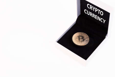 Cryptocurrency text, golden bitcoin in a white gift box with black velvet on a white background. Copy space.の写真素材