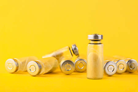 Bubbles, ampoules with dry probiotic, bifidobacteria, with probiotic powder inside on a yellow background. Copy space.の写真素材