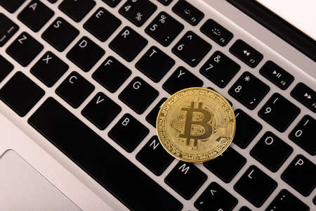 Gold coin Bitcoin, lies on a laptop, keyboard. with a flat layout.の写真素材