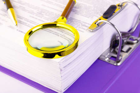 Office, a folder with documents awaiting verification, a magnifying glass in a gold frame. Business and education concept. Copy space. Selective focus.の写真素材