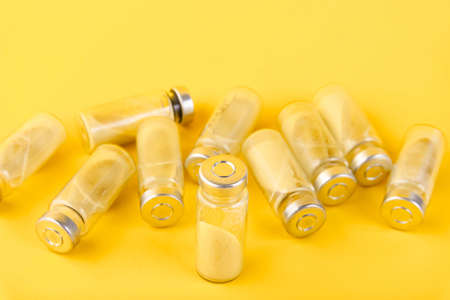 Bubbles, ampoules with dry probiotic, bifidobacteria, with probiotic powder inside on a yellow background. Copy space.の写真素材