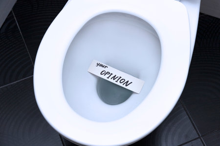 The words, the phrase, YOUR OPINION is written on the note card and floats in the toilet bowl as a...