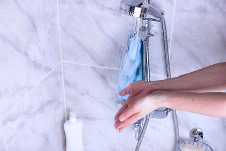 Hand washing process. Female hands under the tap with water in the bathroom.の写真素材