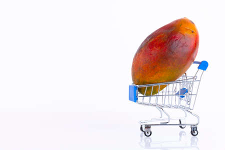 Red mango, a favorite Thai fruit in a shopping trolley, against a white background. ECO, environmentally friendly product. Copy space.の写真素材