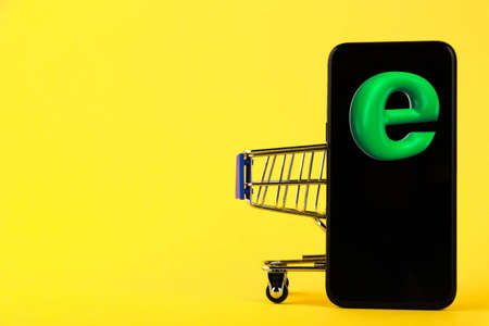 Online shopping, phone and E 3D icon, discount sale shopping cart concept on yellow background. Copy space.の写真素材