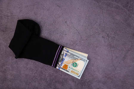 A money sock, a bundle of American hundred dollar bills hidden in a sock. Savings and storage...