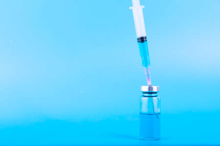 Medical ampoules and syringe on a blue background. Copy space. Selective focusの写真素材