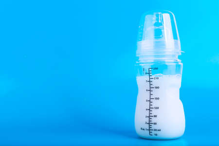 Baby feeding bottle with pacifier on blue background. Copy space.の写真素材