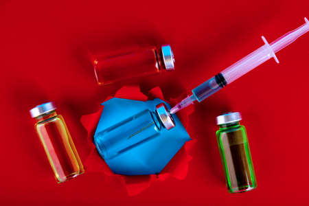Medical ampoules and syringe on a blue background. Copy space. Selective focus