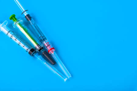 Disposable medical hypodermic syringes on a blue background. Copy space.の写真素材