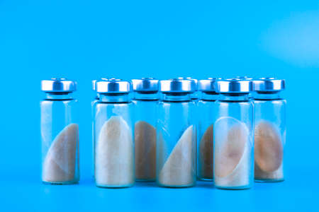 Vials, ampoules with dry probiotic, bifidobacteria, with probiotic powder inside on a blue background. Copy space.の写真素材