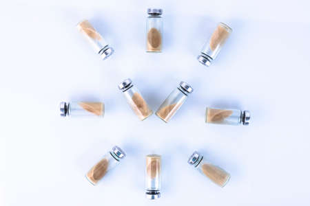 Vials, ampoules with a dry probiotic, bifidobacteria inside on a white background are laid out in the form of a clock. Copy space.の写真素材