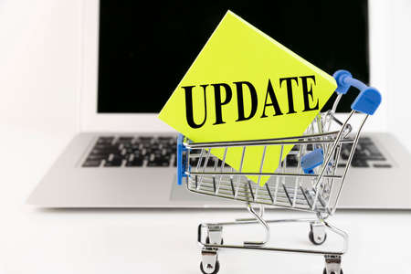 Shopping cart, laptop, text, Update, on yellow paper. business concept.