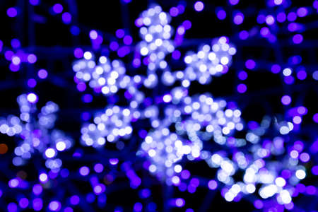Neon, blue glowing snowflakes, colorful background, out of focus.