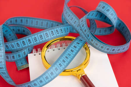 Conceptual diet, healthy eating concept, magnifying glass and measuring tape. Copy space.の写真素材