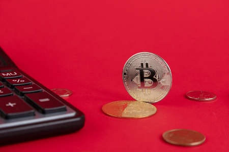 Calculator, Bitcoin coins on a red background. Copy space.の写真素材