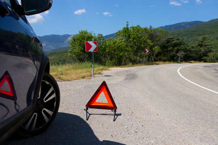 An emergency stop sign of a vehicle is installed on the road, next to the car. Copy space.の写真素材