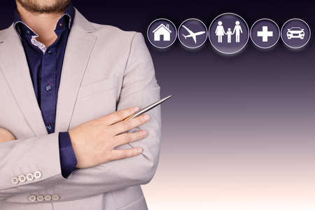 A businessman in a gray business suit with a pen, standing with crossed arms. Copy space. High quality photoの写真素材