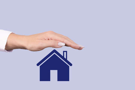 Real estate sale, rental, insurance and protection concept. A female hand covers the icon with a...