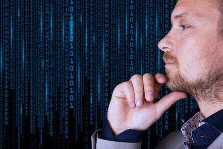 Binary code. A businessman looks at a background of digital binary code numbers. Copy space. High...