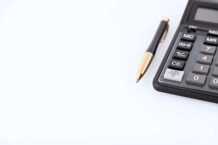 Black color calculator and yellow-black metal pen on a white backgroundFinancial activity, accounting, tax calculation or savings and investments. copyspace. high quality photoの写真素材