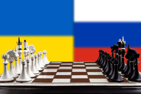 Chessboard with figures on the background of the flags of Ukraine and Russia, a crisis in relations, the concept of strategy in war. high quality photoの写真素材