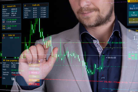 Businessman, broker analyzing stock market changes, falling and rising numbers and lines on the...