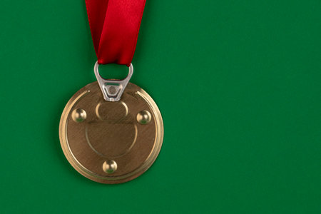 The medal is made from a tin can lid with a red award ribbon on a green background. Antimedalの写真素材